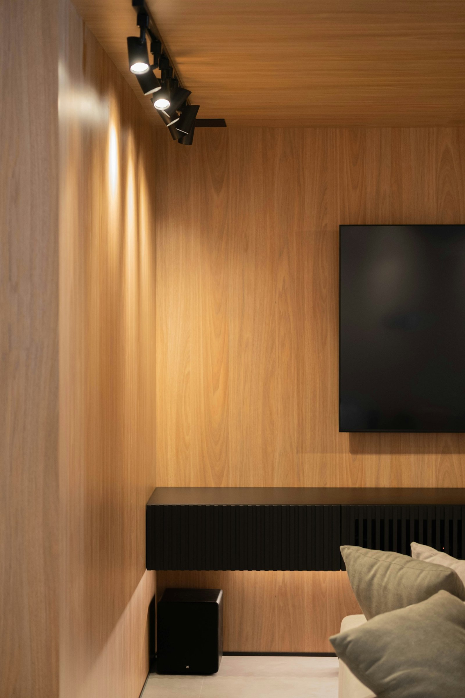 Living contemporâneo com painel contínuo de madeira