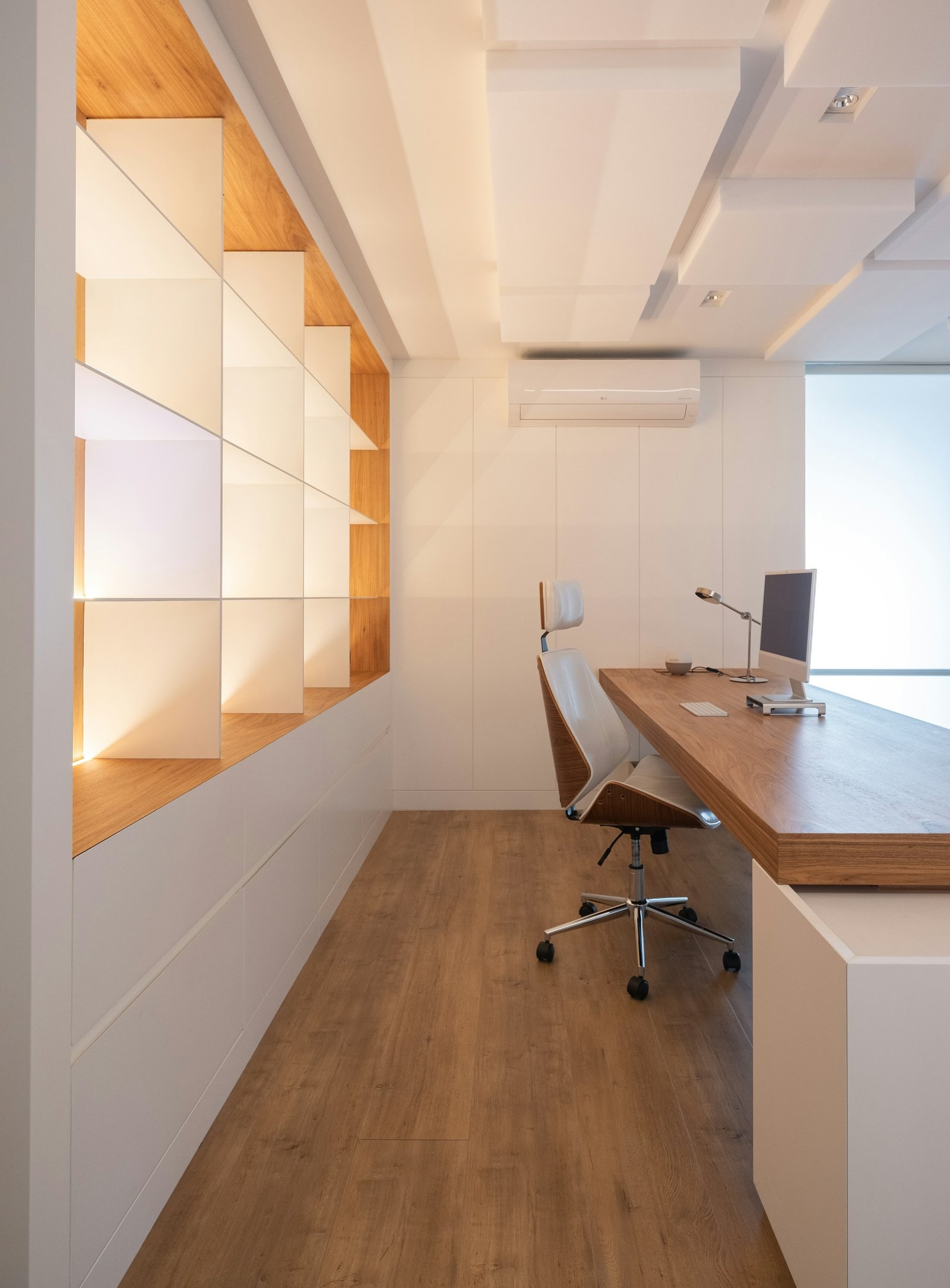 Escritório contemporâneo com bancada e estantes de madeira